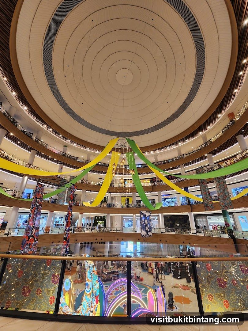 Interior of a multi-level shopping mall with decorative streamers and lights.