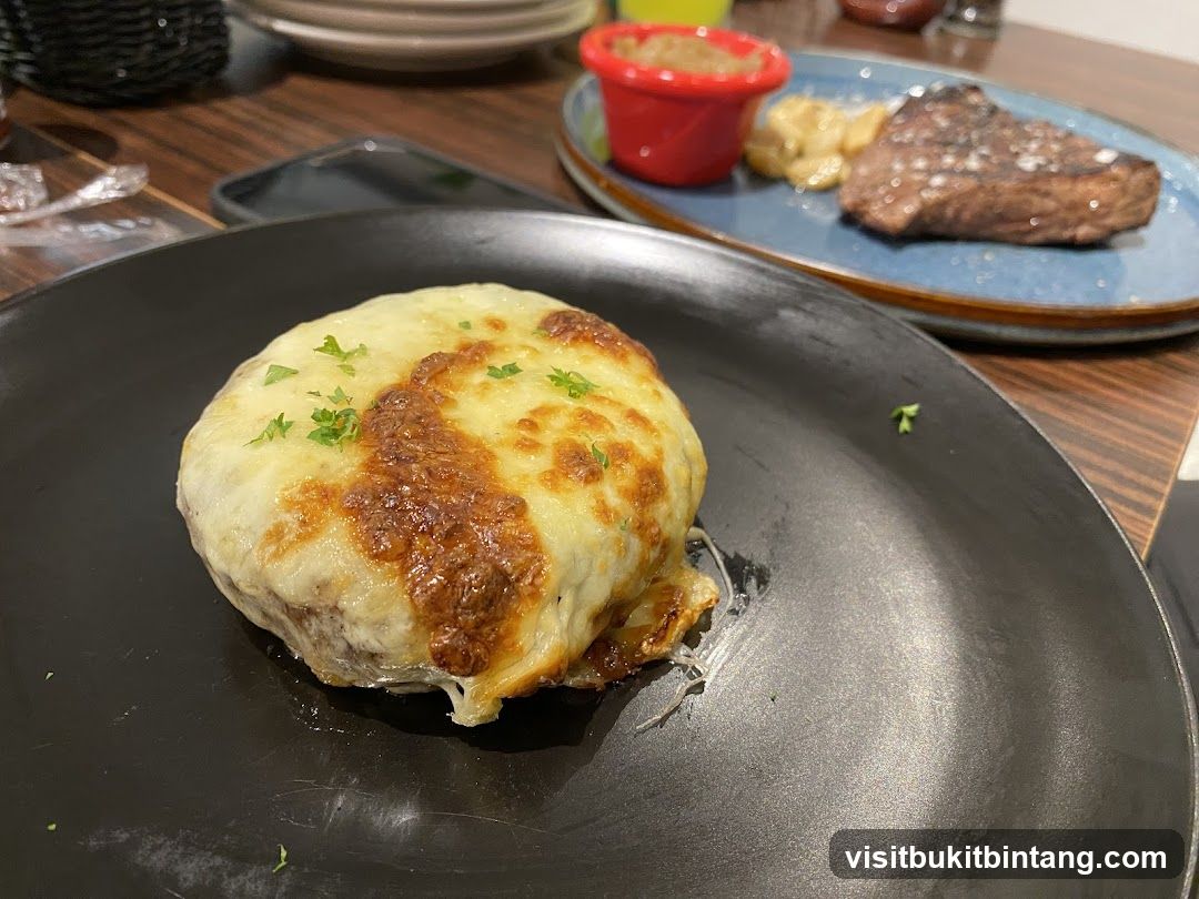 Cheesy dish with steak in the background