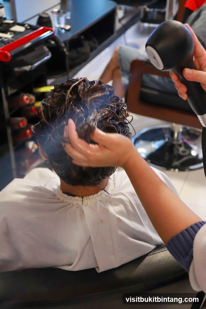 Hairdresser applying product to client's hair