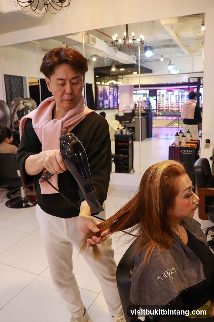 Hairdresser drying client's hair