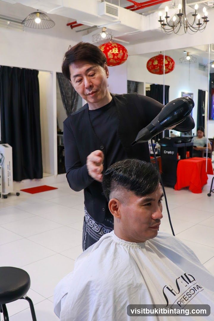 Hairdresser drying client's hair