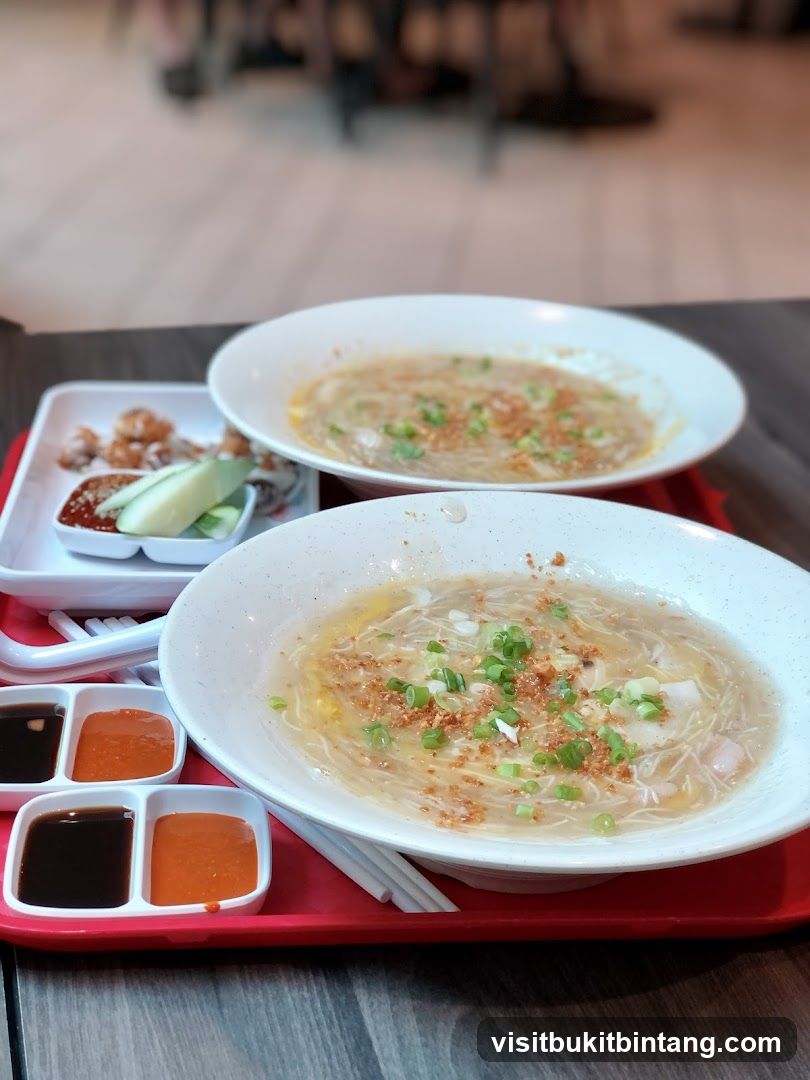 Two bowls of noodle soup with side dishes