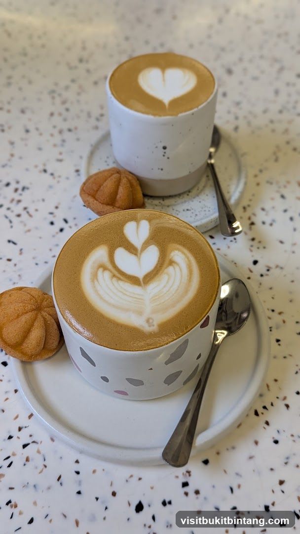Two coffees with latte art and pastries
