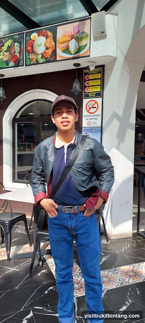 Man Posing in Front of Restaurant with Food Displays