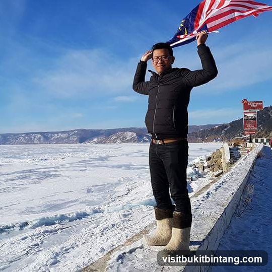 Man holding Malaysian flag on frozen lake