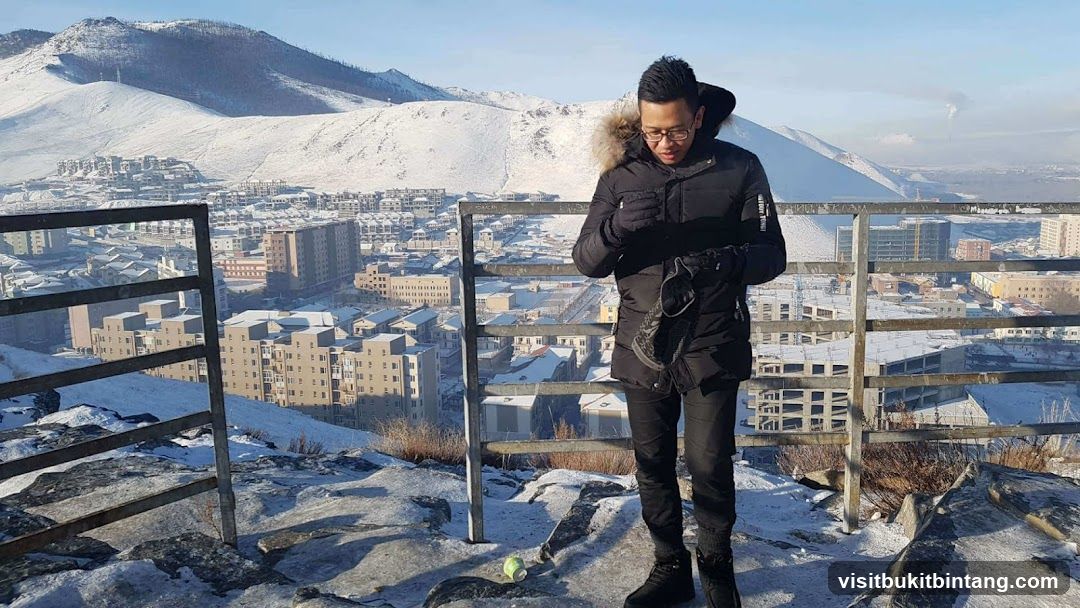 Man in Winter Coat Overlooking Snowy City