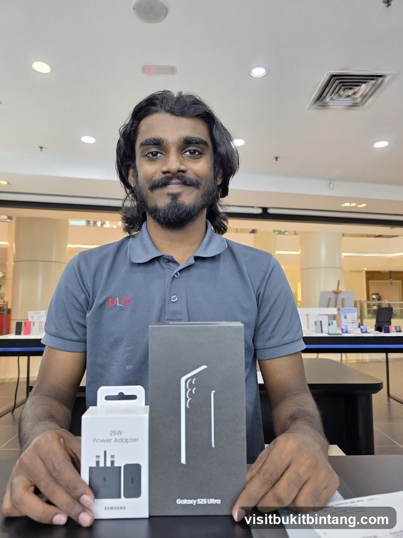 Man holding Samsung Galaxy S25 Ultra box and power adapter