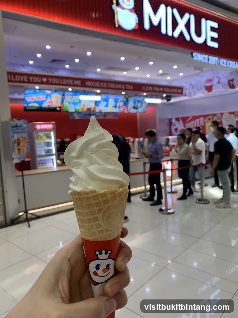 Person holding an ice cream cone in front of a MIXUE store