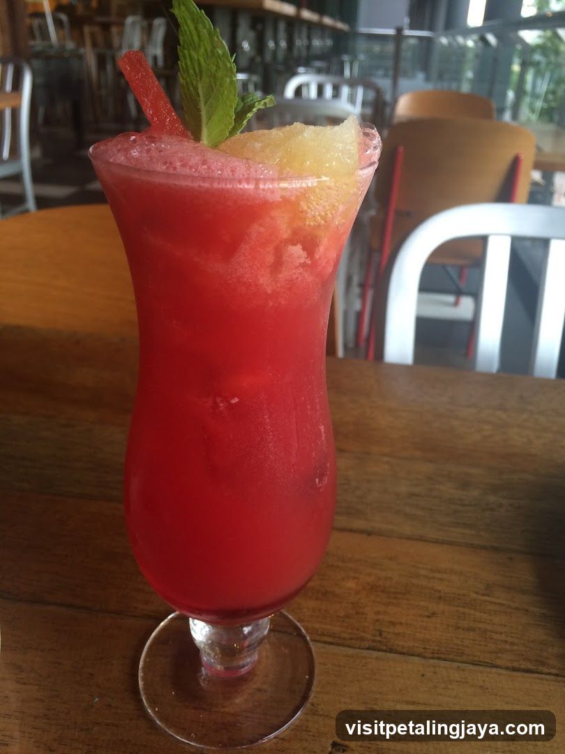 Red Cocktail with Mint and Pineapple Garnish