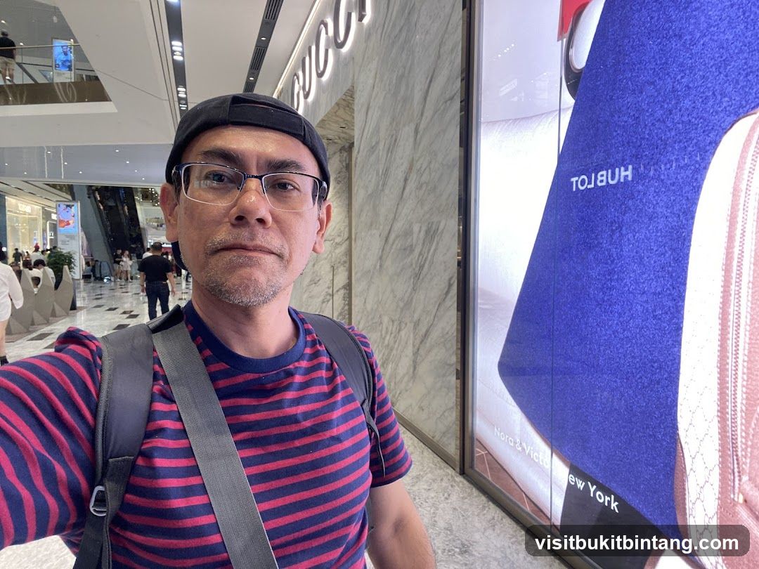 Man in a mall with a large advertisement