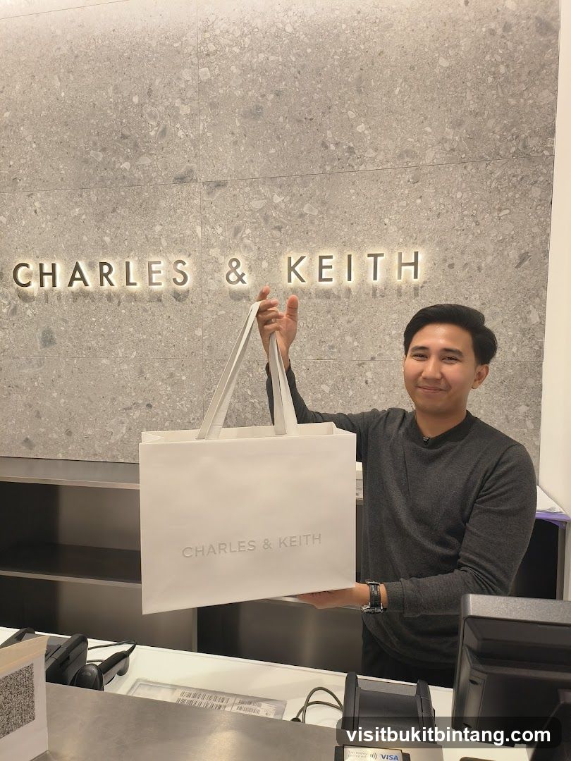 Man holding a Charles & Keith shopping bag