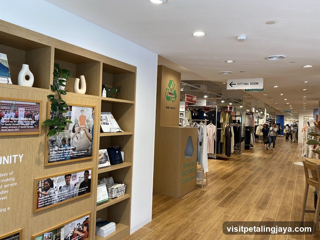 Interior of a clothing store with display shelves and fitting room sign