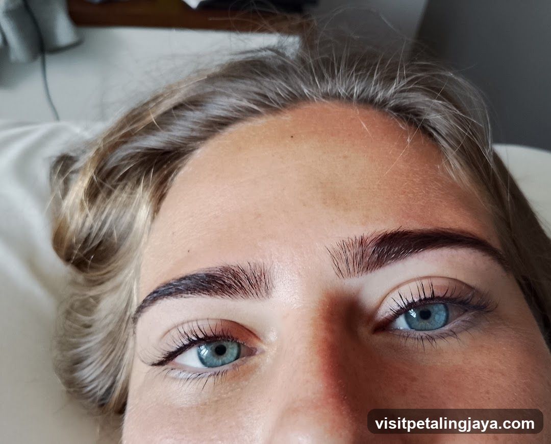 Close-up of a person's face with blue eyes and styled eyebrows