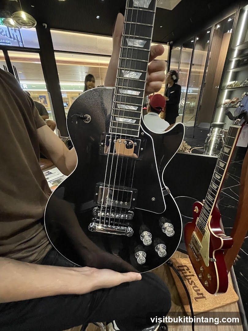 Person holding a black electric guitar
