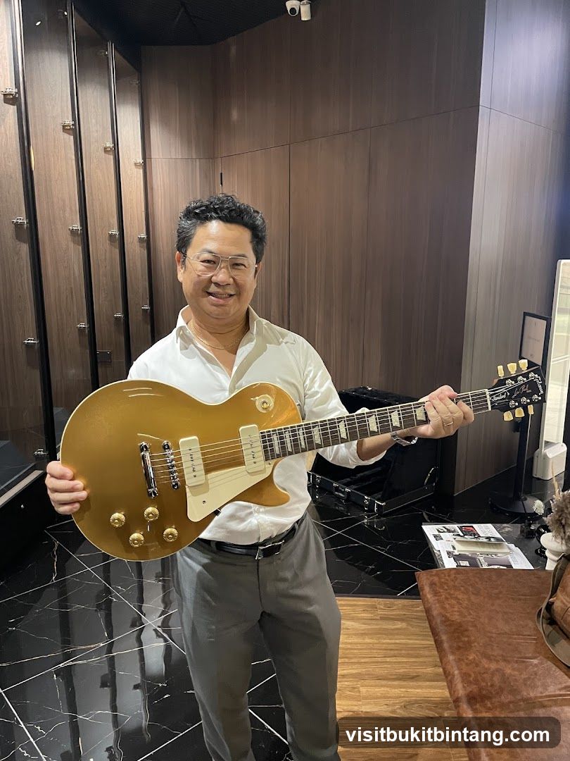 Man holding a gold electric guitar