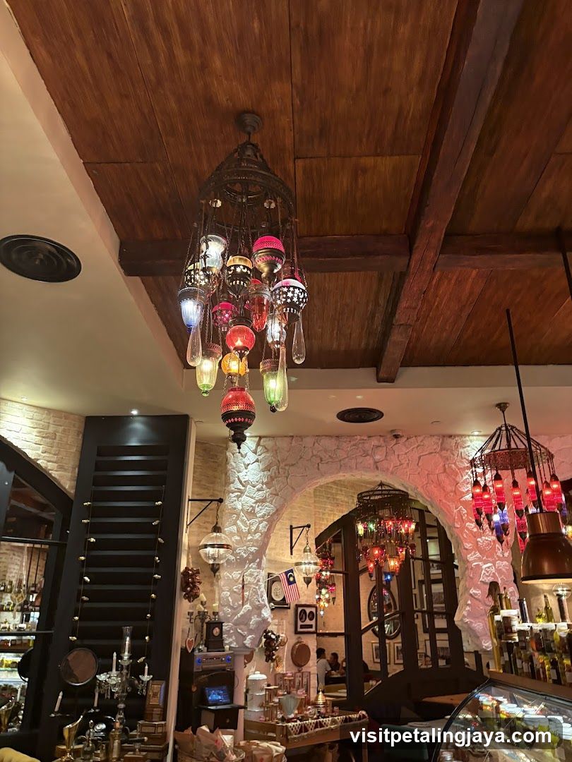 Interior of a restaurant or cafe with decorative lighting and stone walls.