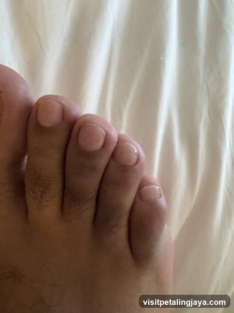 Foot with toes on white fabric background