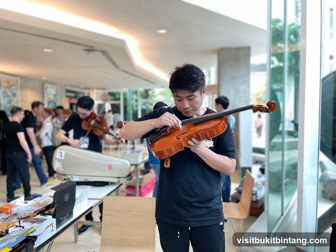 Man Adjusting Violin Strings