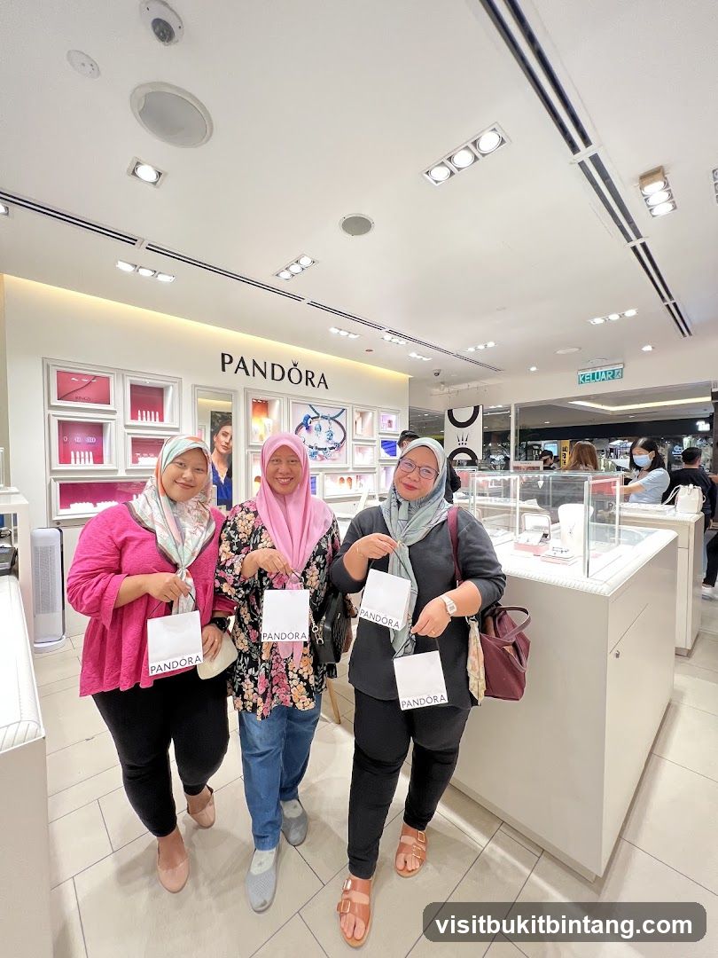 Three women posing with Pandora shopping bags