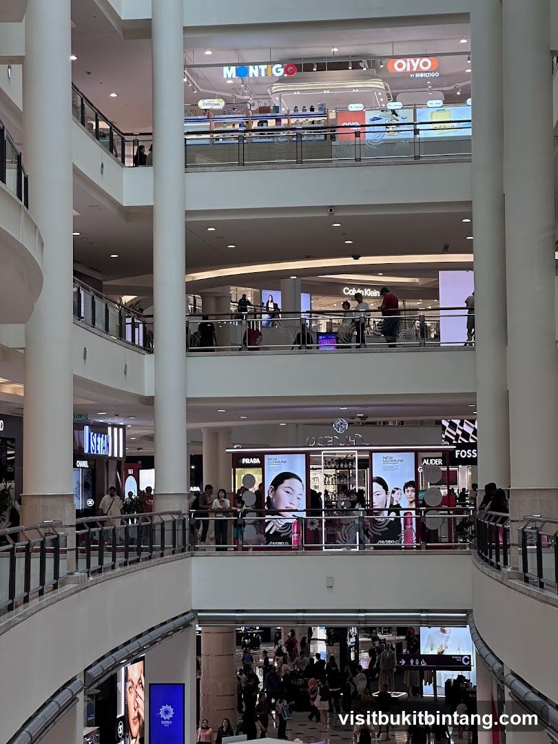 Multi-level shopping mall interior with various stores
