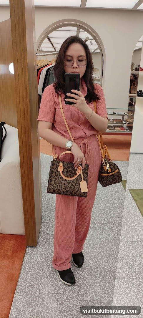 Woman Posing with Handbags in Store