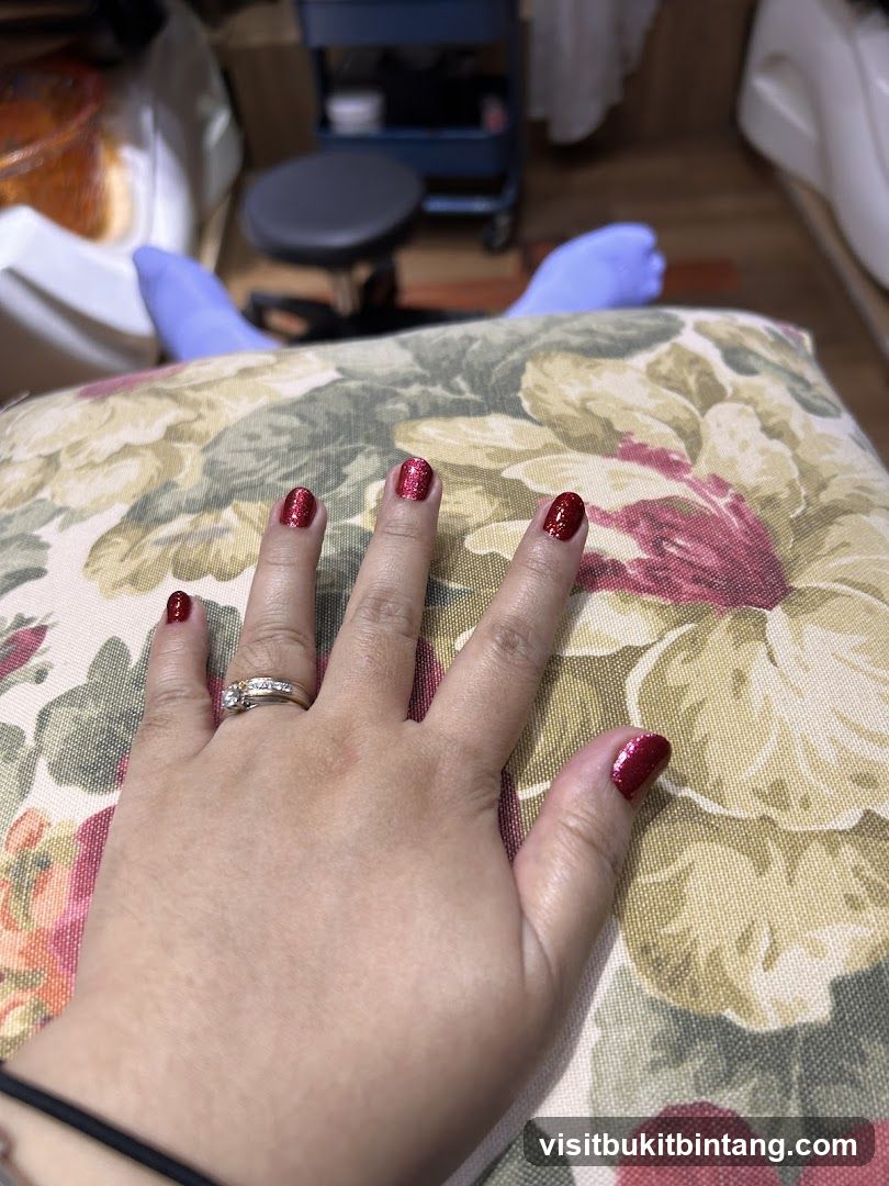 Hand with red glitter nails