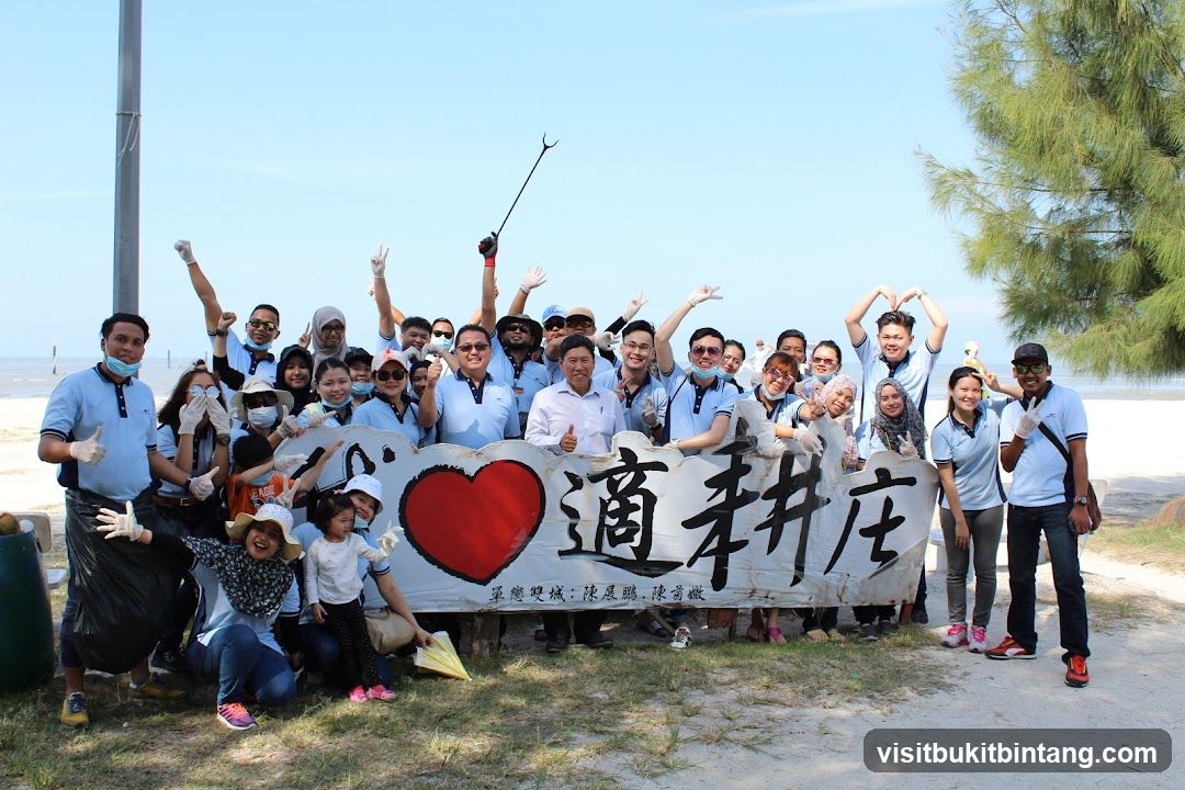 Group posing with banner on beach