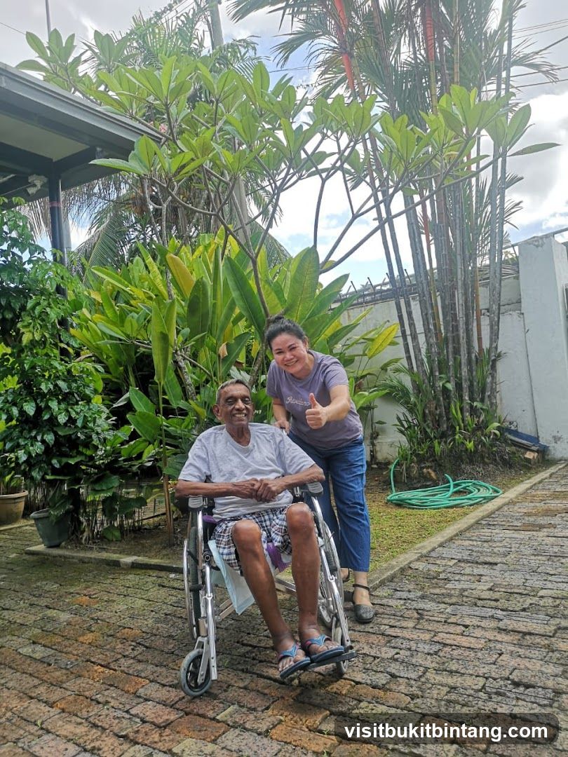 Elderly man in wheelchair with caregiver