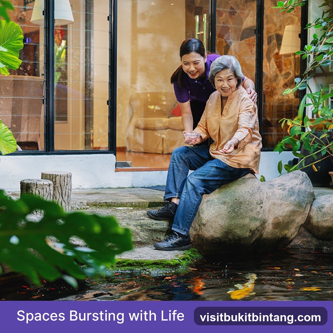 Elderly woman and caregiver by a pond