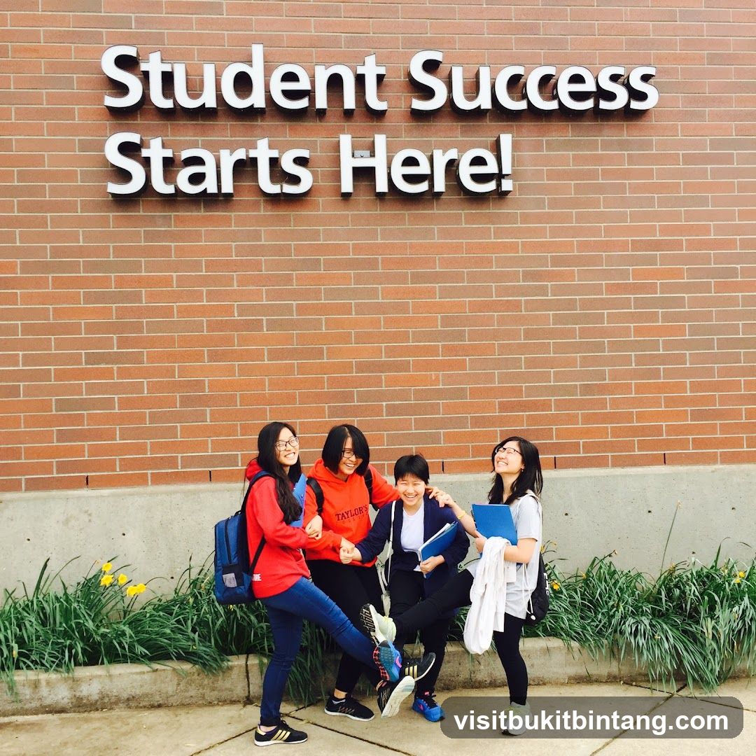 Students posing in front of a brick wall with text