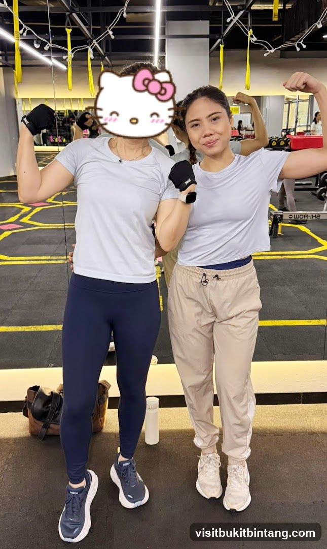 Two women flexing muscles in a gym