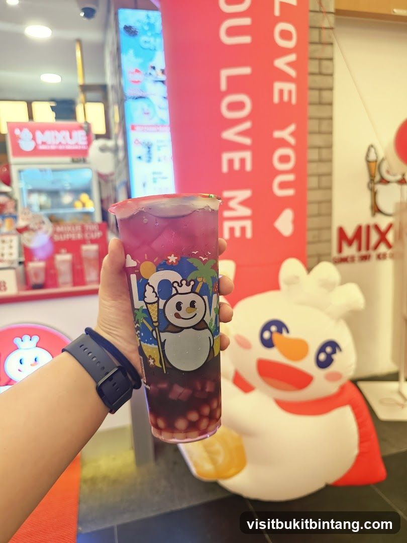 Person holding a bubble tea with a snowman decoration