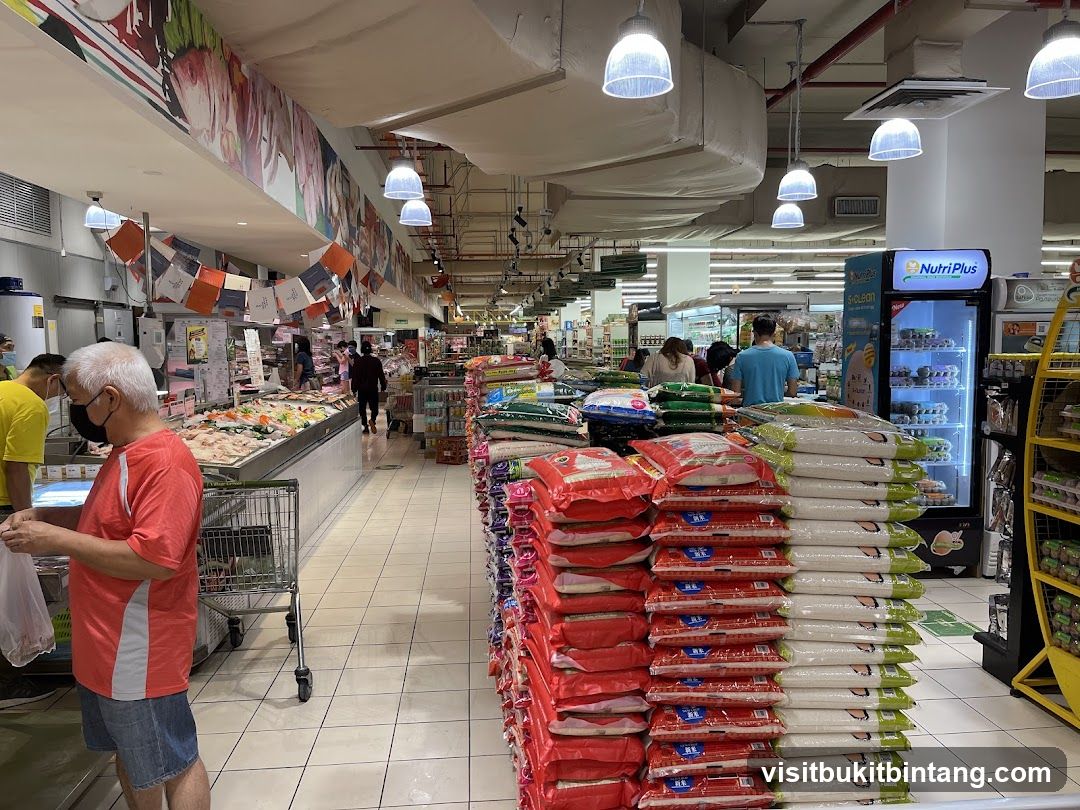 Supermarket aisle with stacked rice bags and refrigerated display