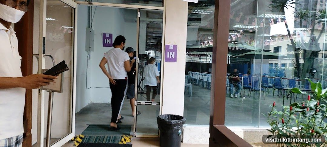 People entering a building with 'IN' signs