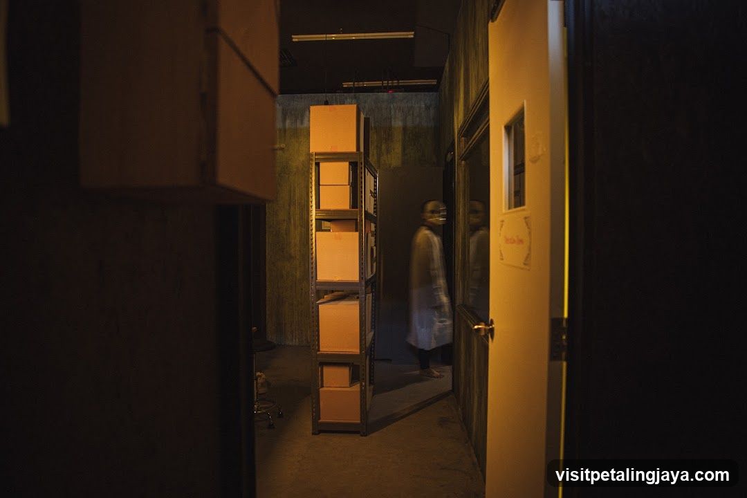 Dimly lit corridor with shelving and person in white coat