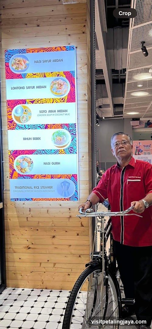 Man with bicycle near menu board