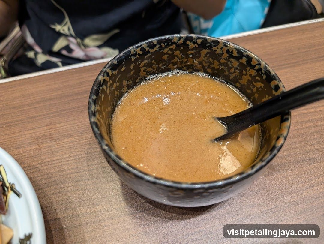 Bowl of Brown Soup with Spoon