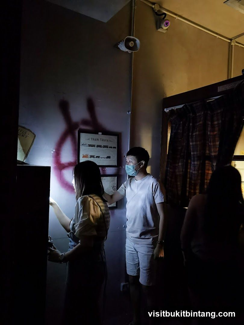 People in dimly lit room with train trivia poster