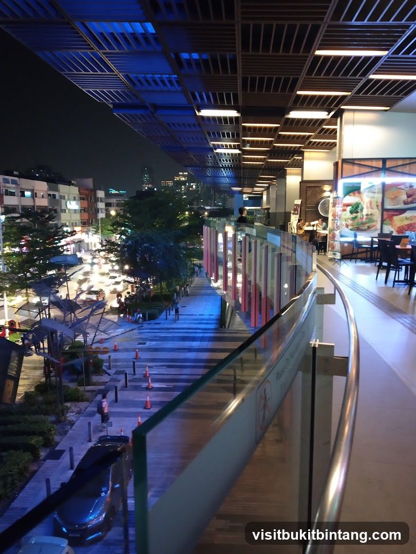 Nighttime view of a walkway and shops