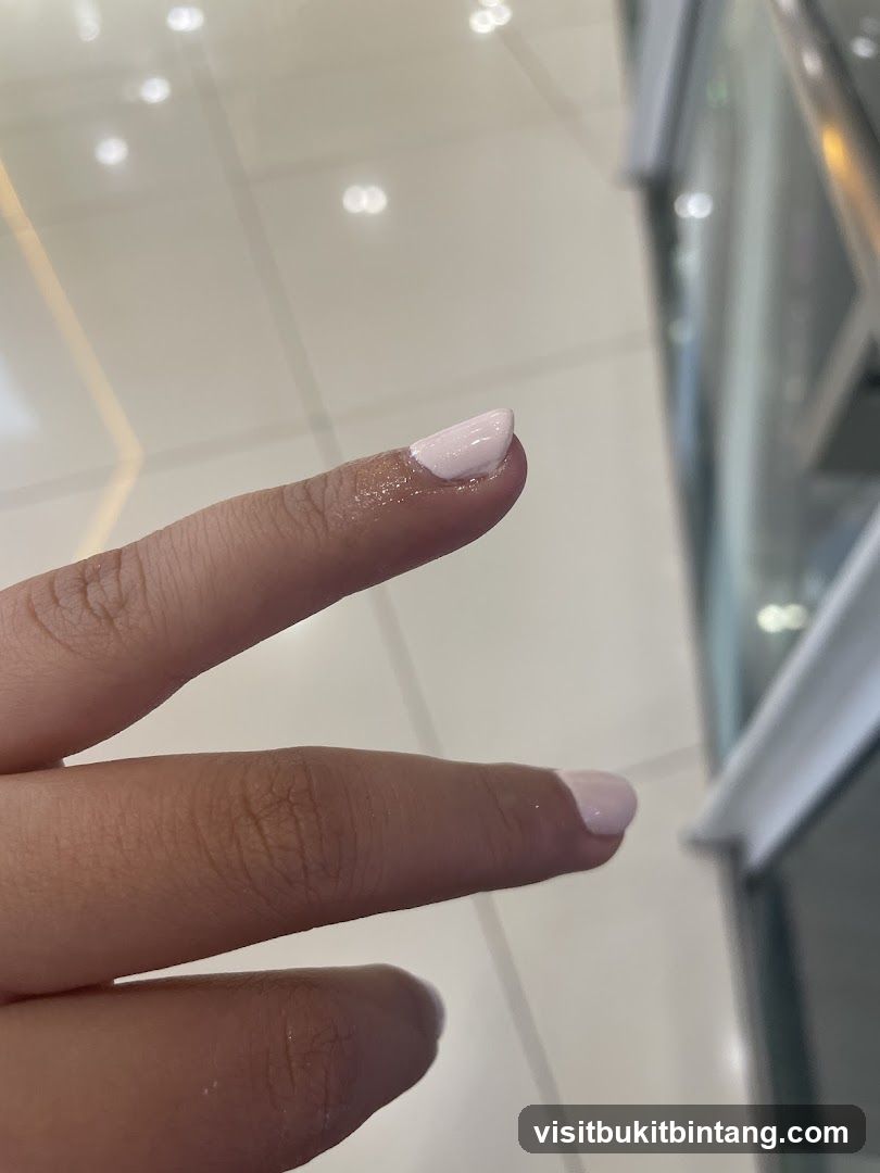 Close-up of a hand with light pink nail polish