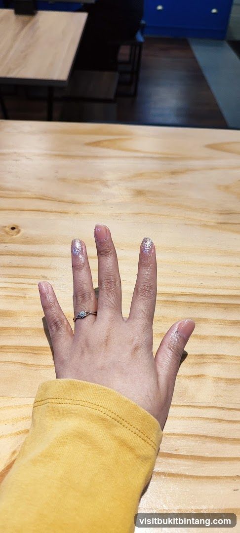 Hand with Ring on Wooden Table