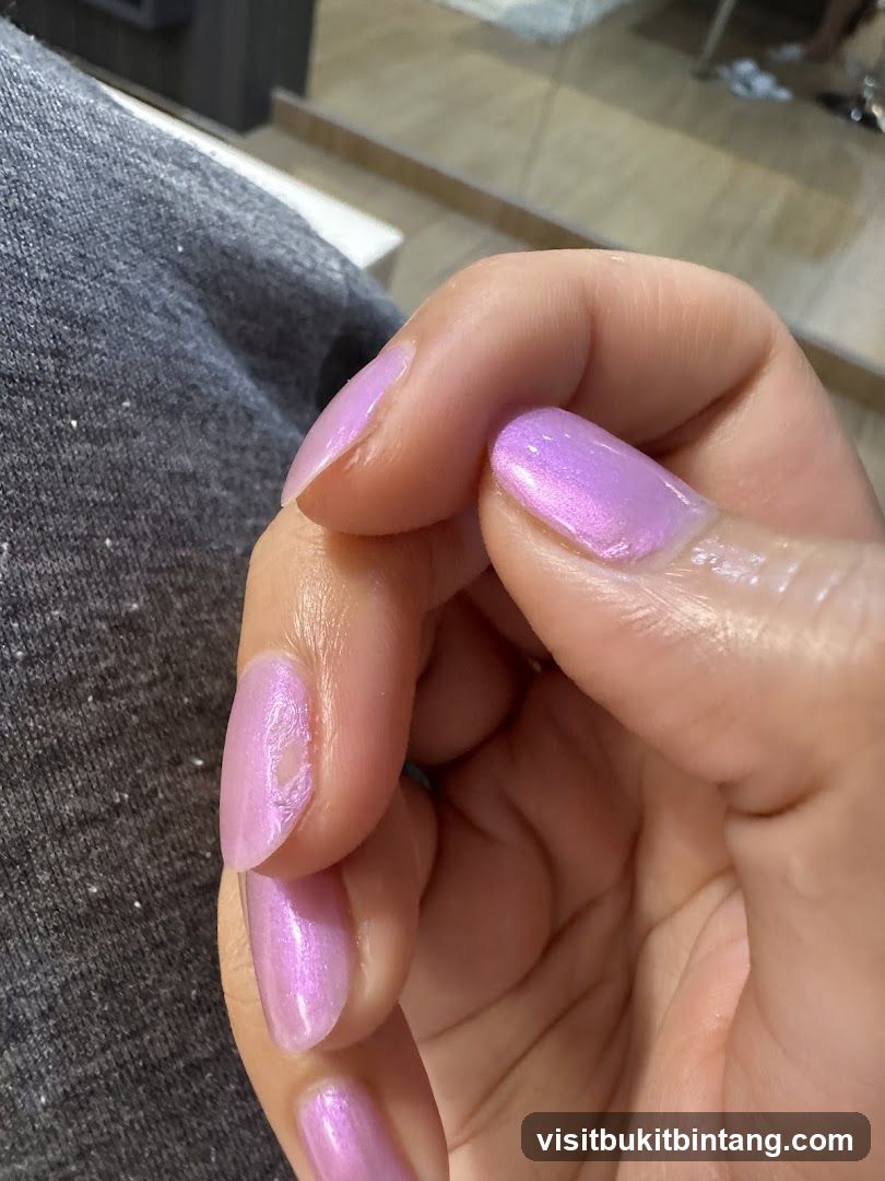 Close-up of a hand with chipped pink nail polish