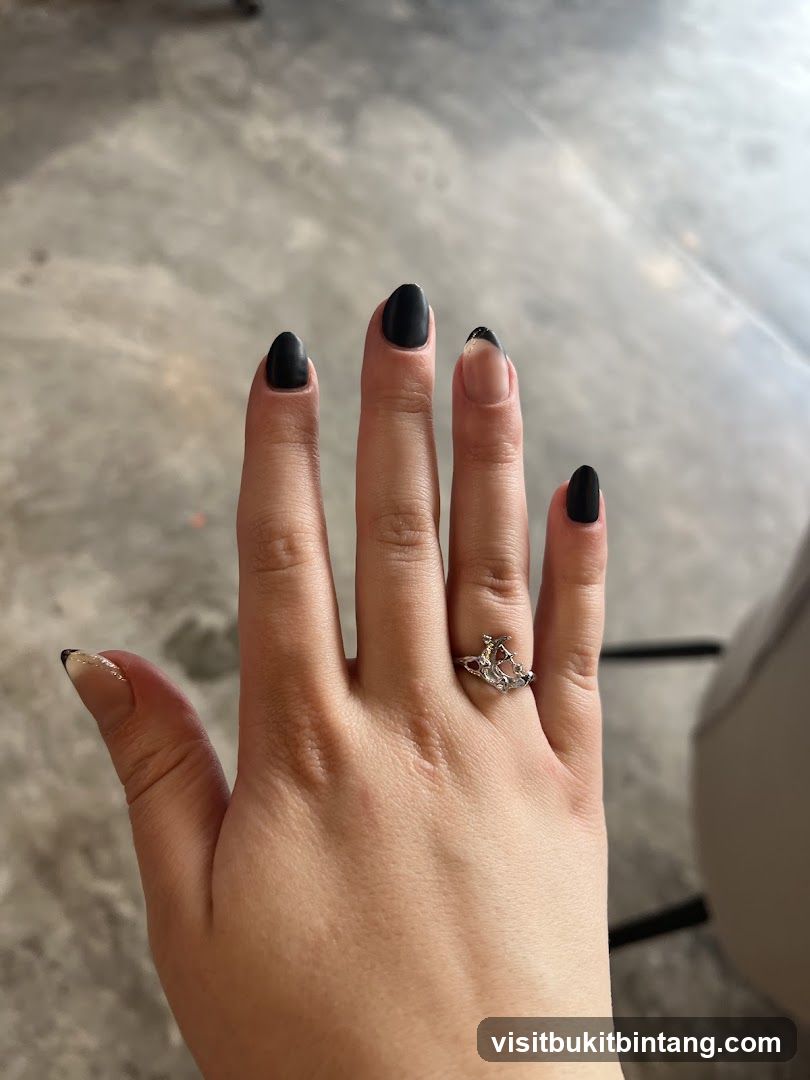 Hand with black nails and ring