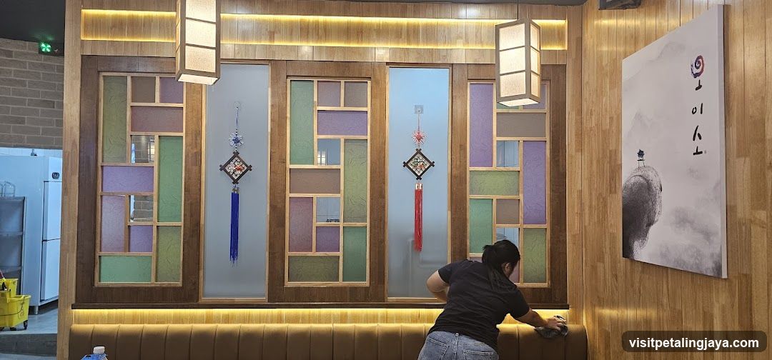 Interior of a restaurant or cafe with decorative wall panels and staff cleaning