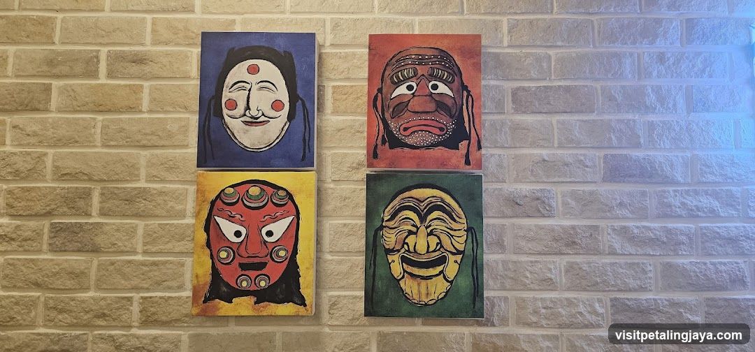 Four Painted Masks on Brick Wall
