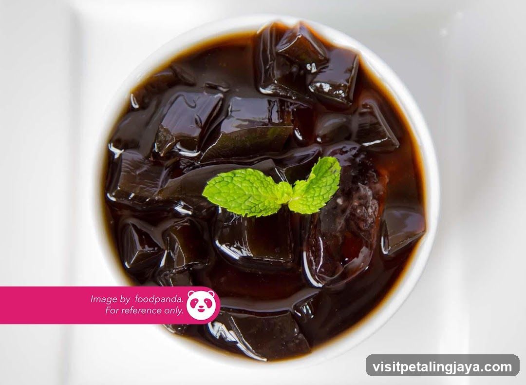Bowl of black jelly dessert with mint garnish