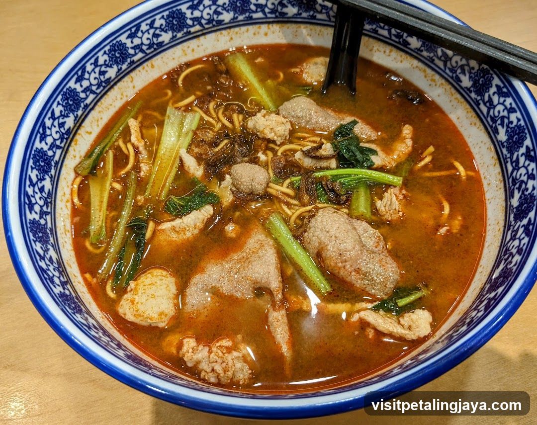 Bowl of Spicy Noodle Soup with Meatballs and Greens