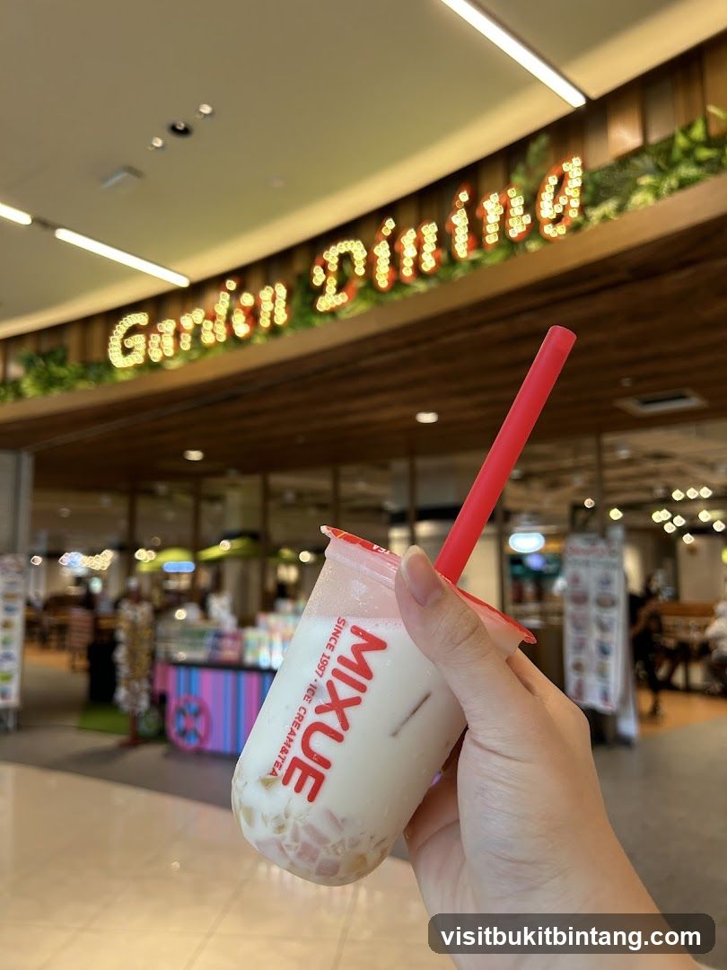 Hand holding a bubble tea drink with a store sign in the background