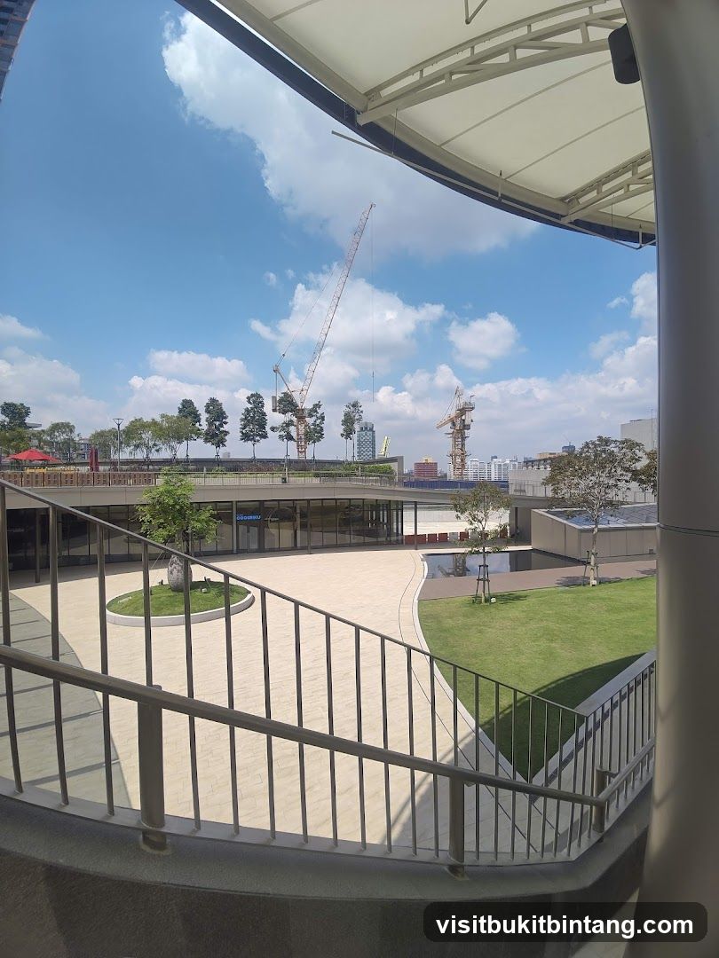 Outdoor plaza with construction cranes in the background