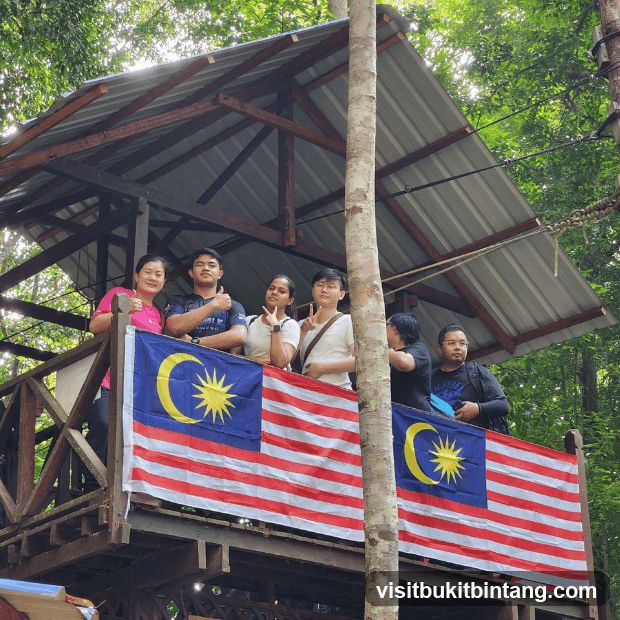 Group on a wooden platform with Malaysian flags